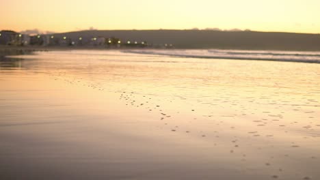 Schaum-Von-Der-Küste-Auf-Nassem-Sand,-Bei-Sonnenuntergang