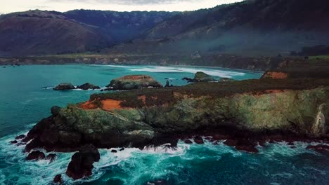 Volando-Sobre-Enormes-Acantilados-Rocosos-Y-Olas-Rompiendo-En-La-Playa-Sand-Dollar-En-Big-Sur-California-Al-Atardecer