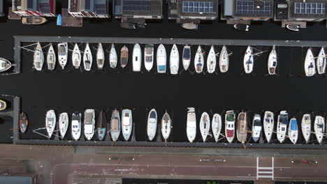 Aerial-footage-of-sailing-boats-at-a-harbor-at-Bunschoten-Spakenburg,-The-Nederland-Flying-downwards