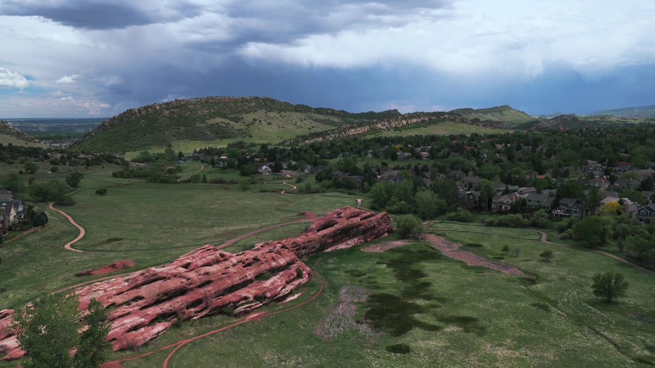 Red Rocks i Ken Caryl Valley Ranch, bostadsområden i North Valley Meadow Ranch, Front Range, Denver, Colorado. Drönarvy över Klippiga bergens fot en molnig sommarmorgon, vandringsleder, framåtrörelse.