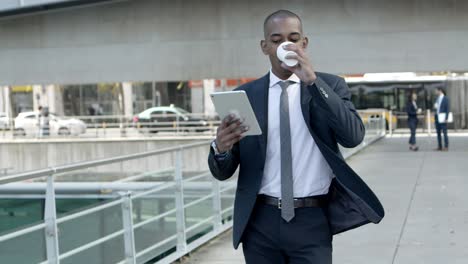 businessman with paper cup and tablet pc