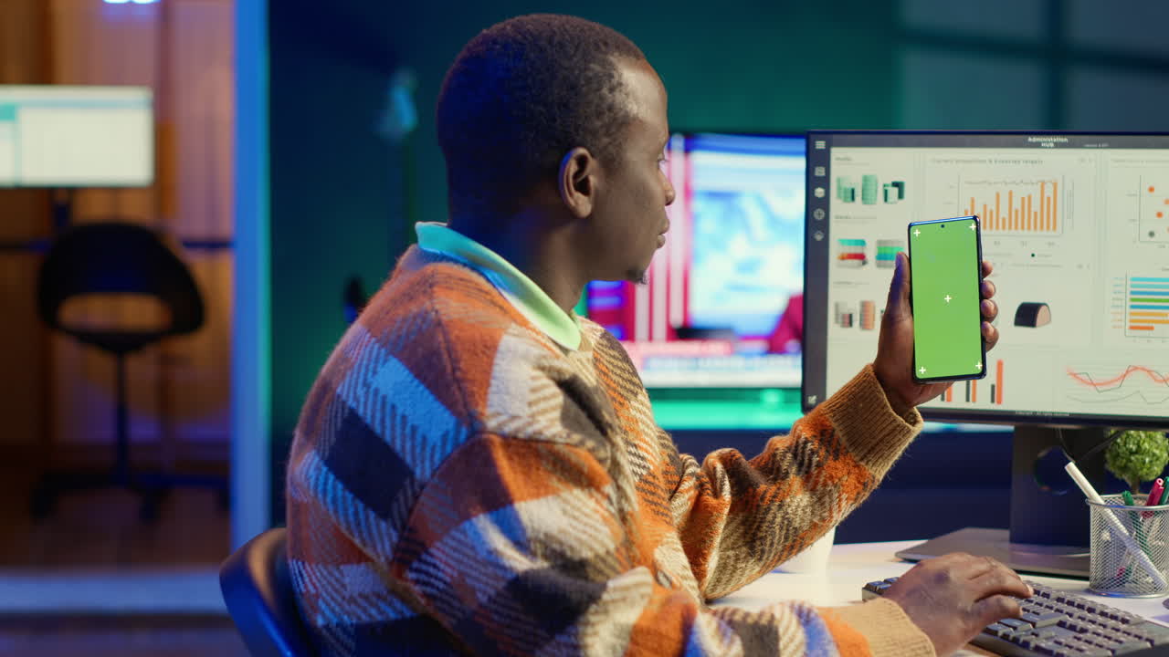 Man working in office with green screen smartphone