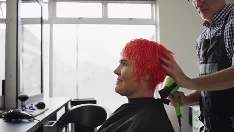 side view woman having her hair dry by a hairdresser