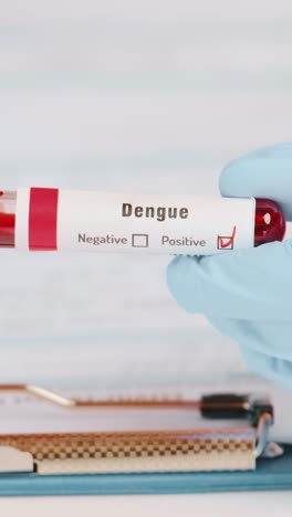 doctor displays positive dengue blood test result in clinical setting