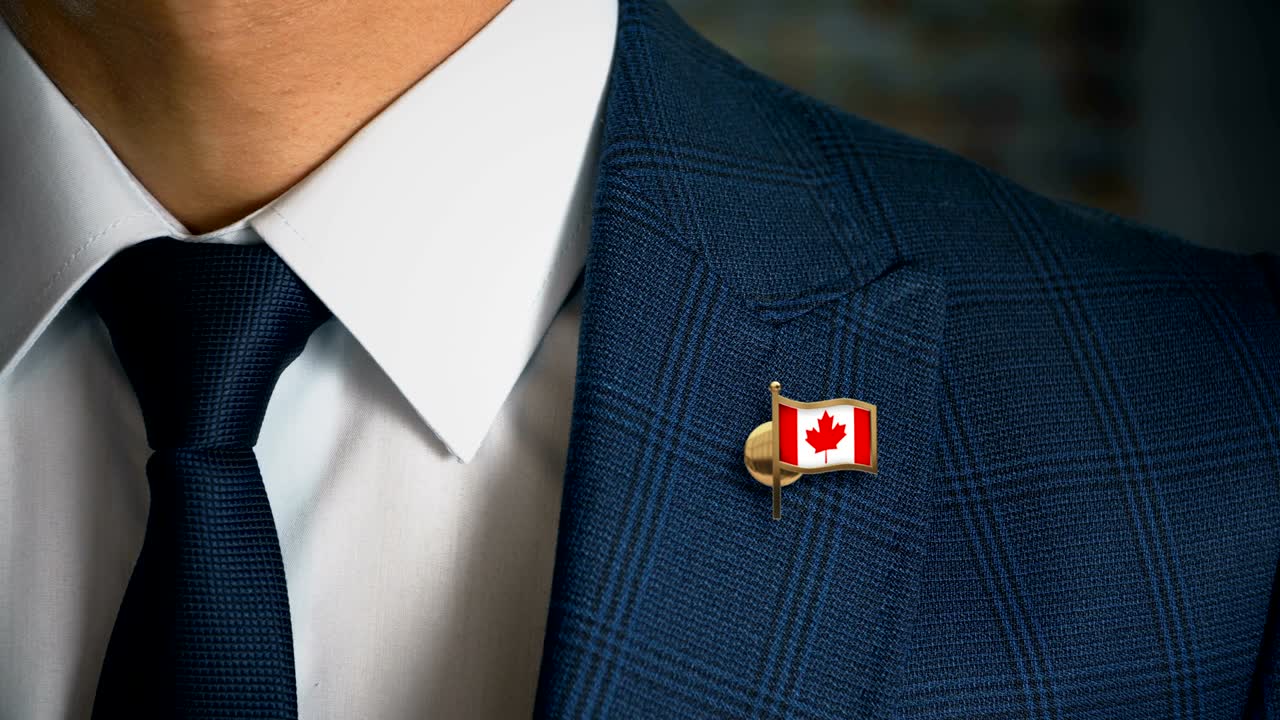 Businessman Walking Towards Camera With Country Flag Pin - Canada