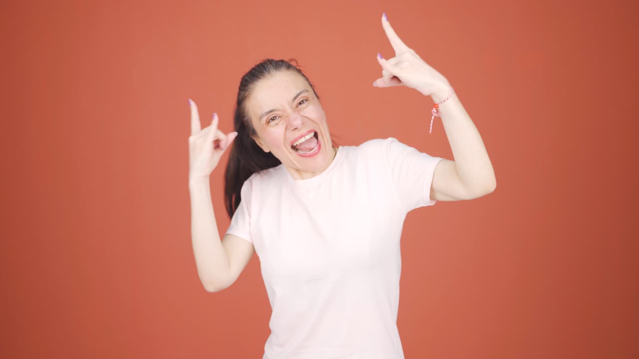 로커 기호를 하고 춤을 추는 여자.