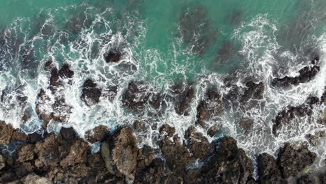 Drone-aerial-shot-of-foaming-waves-hitting-rocks-in-Kenting-National-Park,Taiwan