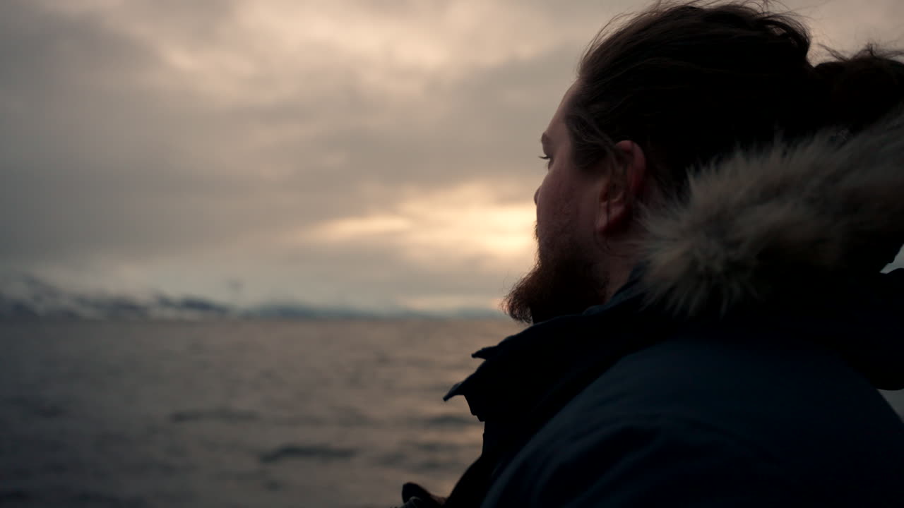 observador de ballenas con cámara filmando al anochecer en skjervoy, noruega. primer plano, toma amplia