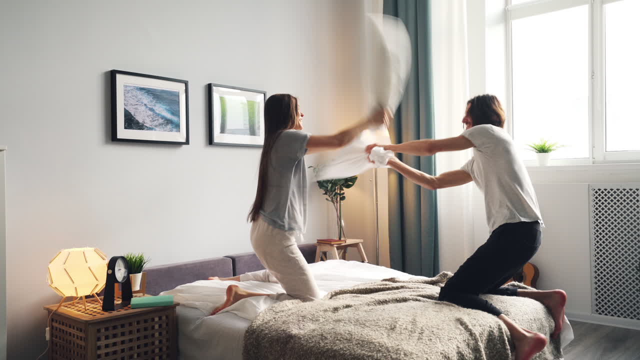 Couple Having a Pillow Fight in Bedroom