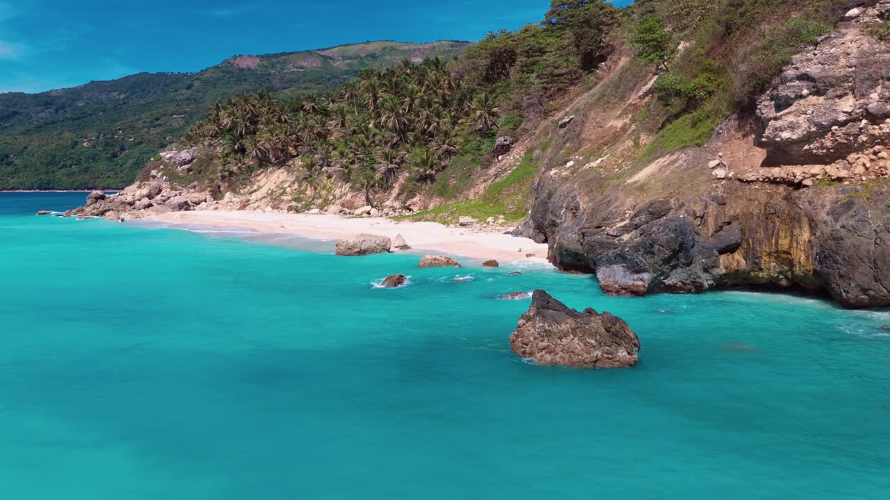 Peaceful hidden sandy beach with clear turquoise Caribbean Sea water in Barahona, Dominican Republic Island. Aerial view. Rocks in water. Sunny Summer day