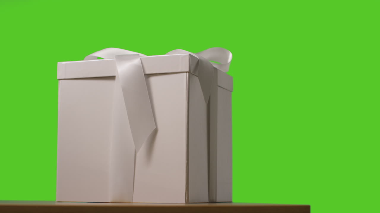 близкий взгляд на подарок, упакованный в подарок, украшенный лентой на столе, снятый на зеленом экране 4