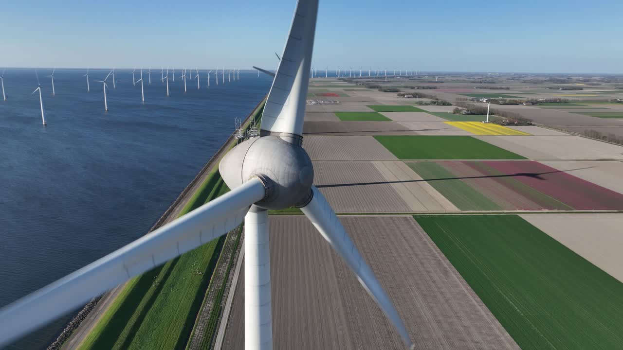 wind turbine along the water line. Renewable energy, clean energy, energy transistion. Aerial drone video.