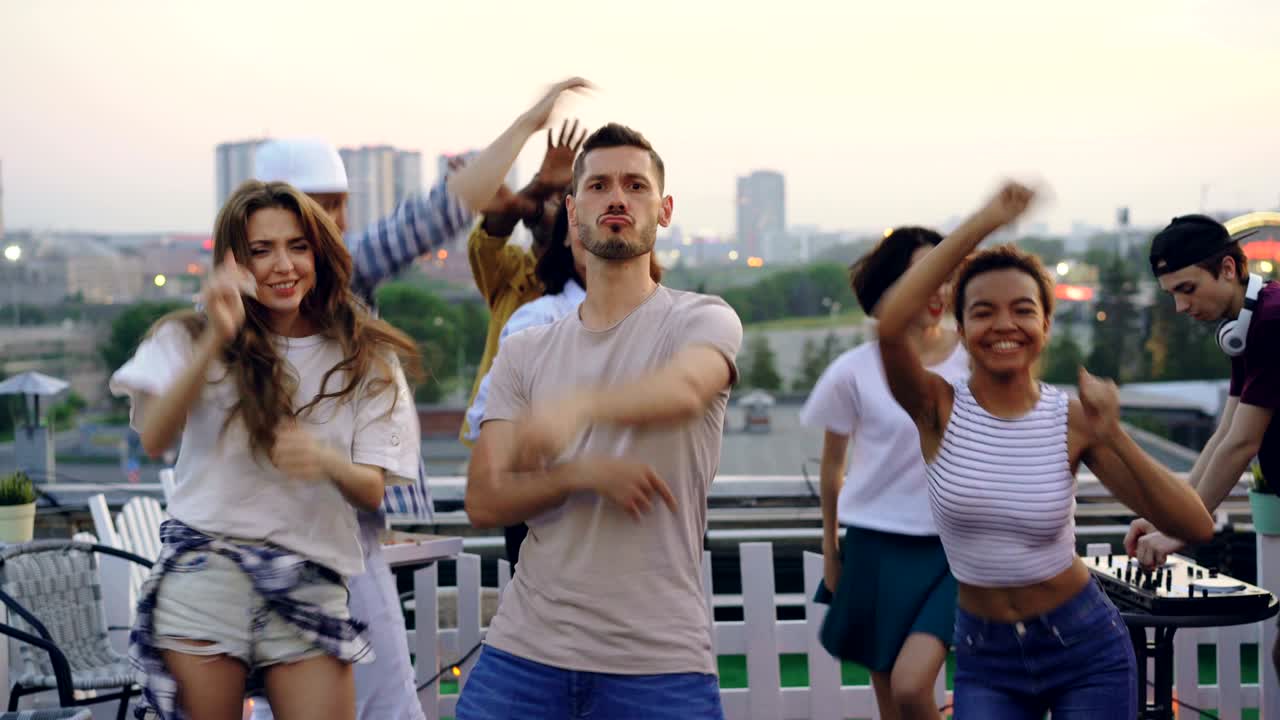 Sudden mood change of group of friends standing with sad faces then enjoying rooftop party, dancing and smiling feeling happiness. Feelings, changing and friendship concept.