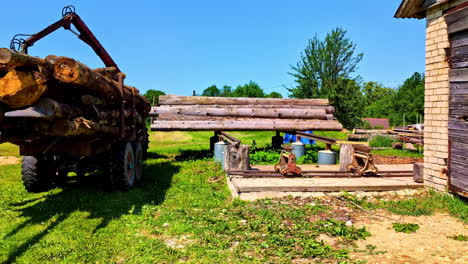 long trailer with stacked logs in residential backyard garden ready for transport removal