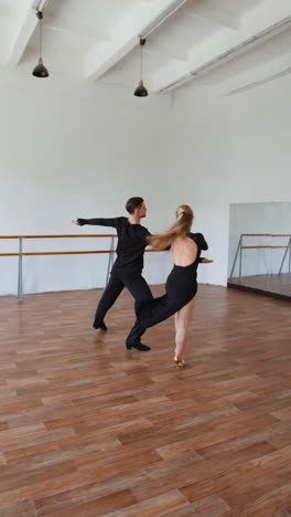 dynamic ballroom dance couple practicing in a studio