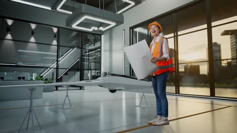 mujer ingeniera revisando el plan del avión no tripulado en una instalación moderna