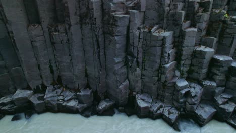 aerial: studlagil river canyon close up details of basalt columns in northeast iceland