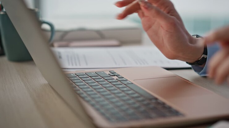 Manicured fingers pressing keyboard laptop in modern office environment closeup