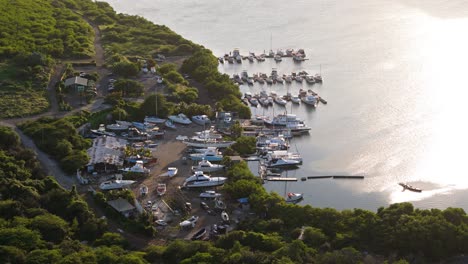 Das-Licht-Des-Sonnenaufgangs-Glitzert-Auf-Den-Karibischen-Gewässern-Im-Hafen-Von-Piscadera,-Angedockten-Fischerbooten-Und-Yachten