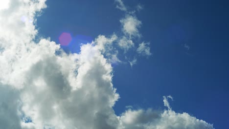 4k timelapse of a sunny blue sky, with clouds passing by in front of the sun