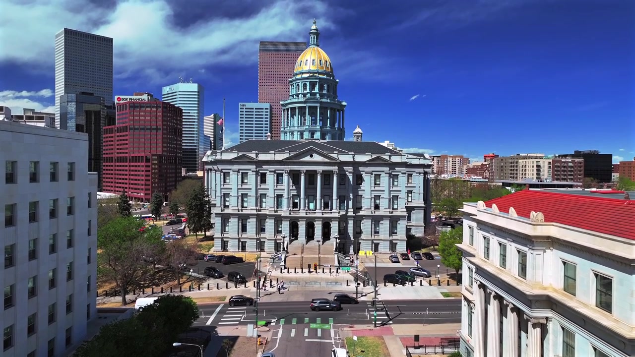 Tour del centro di Denver, mattina di primavera soleggiata, cielo blu, Capitol Hill Civic Center Park, edificio del Campidoglio del Colorado, drone aereo, cupola dorata, grattacieli, edifici, traffico automobilistico, strade cittadine, panoramica in avanti.