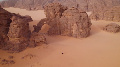 tourist walking near elephant-shaped rock formation at sunset