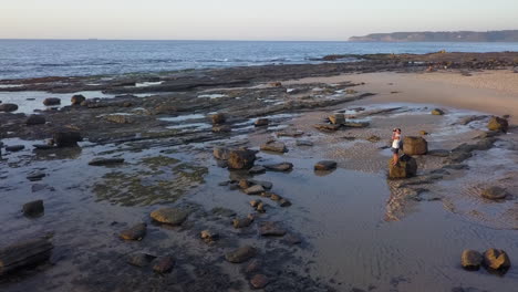 golden hour aerial orbits photographer on beach taking sunrise picture