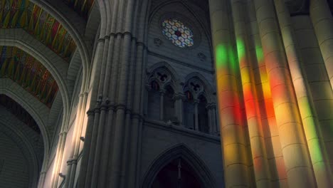 sunlight falls trough stained glass inside la almudena cathedral in madrid. fast camera movement