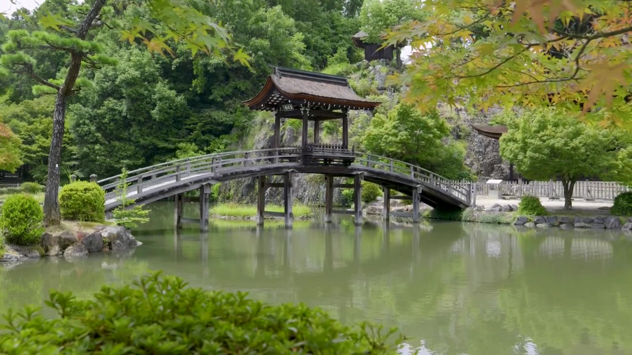 Pomalý záběr sliderem přes krásný dřevěný most u japonského chrámu.