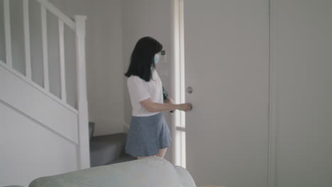 casual woman arriving home and taking safety mask off