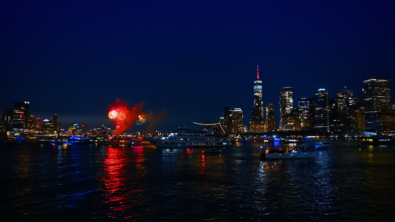 Beautiful night skyline of modern New York, USA with fireworks flashes. Numerous boats are watching the show on the river