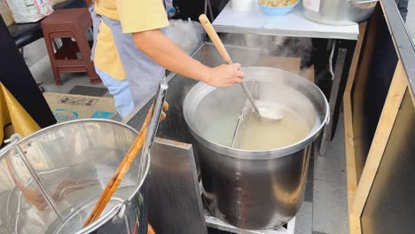 street food vendor preparing noodle soup