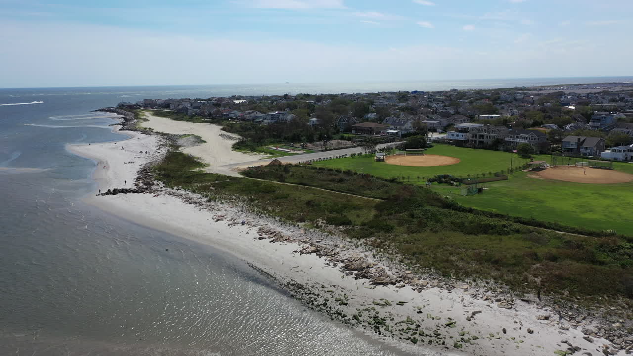 una vista aérea sobre las aguas, frente a una playa vacía en un día brillante y soleado en el verano
