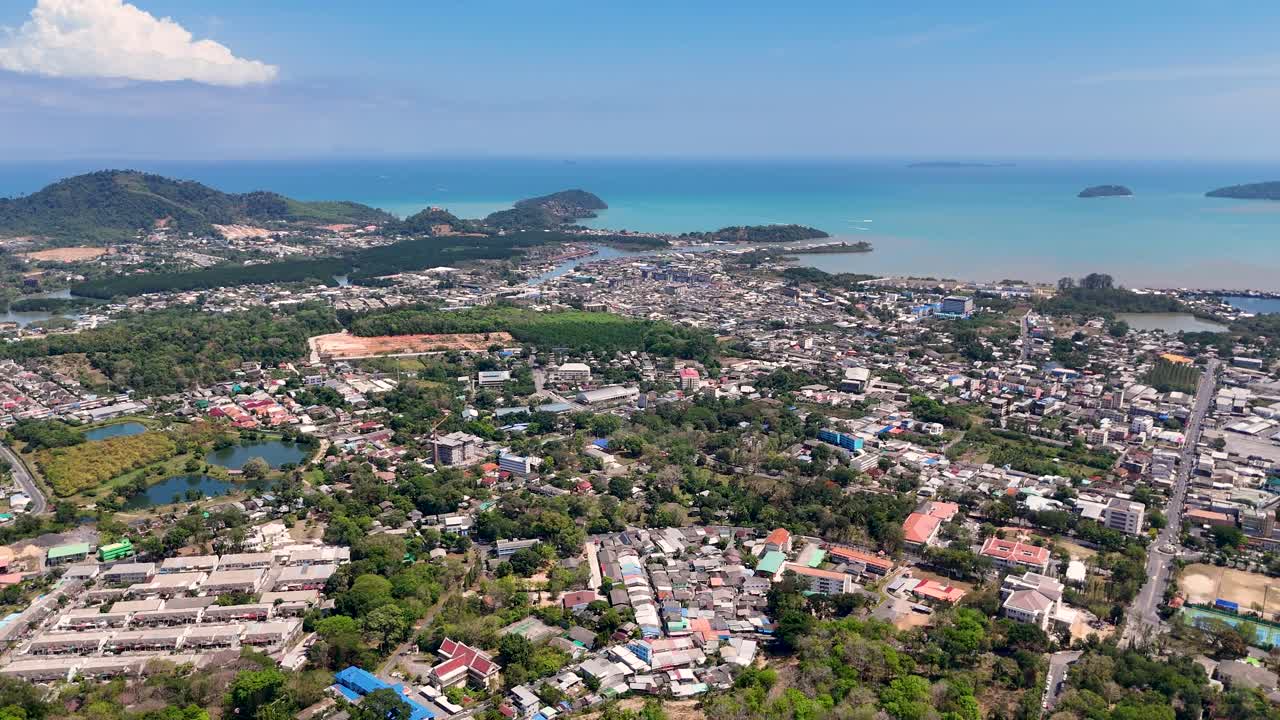 Drone footage captures Phuket's vibrant cityscape and stunning coastline under clear skies, highlighting the Andaman Sea's beauty