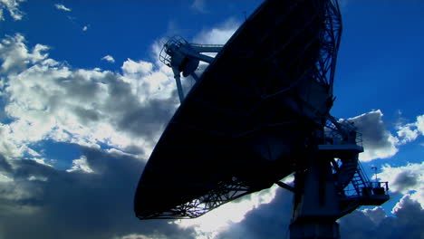 a satellite dish is silhouetted against the sky