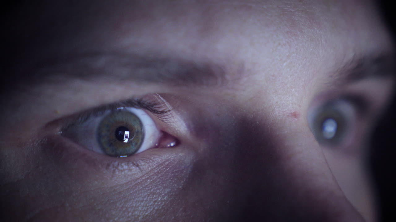 uomo che scorre sul suo telefono in un ambiente buio