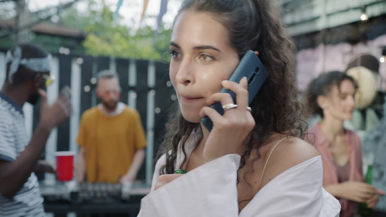 Woman talking on phone at a backyard party