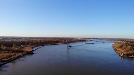 Remolcador-Tirando-De-Una-Grúa-Flotante-A-Través-Del-Río-En-Barendrecht,-Países-Bajos