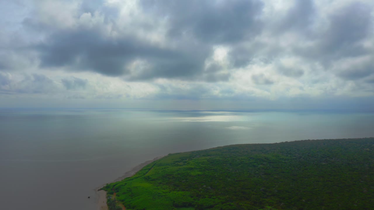 la cámara se eleva por encima de las aguas cristalinas de una paradisíaca playa de nueva caledonia, capturando la extensa costa en su totalidad