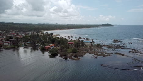 aerial shot of small caribbean town by the sea paning left, palenque, colon, panama