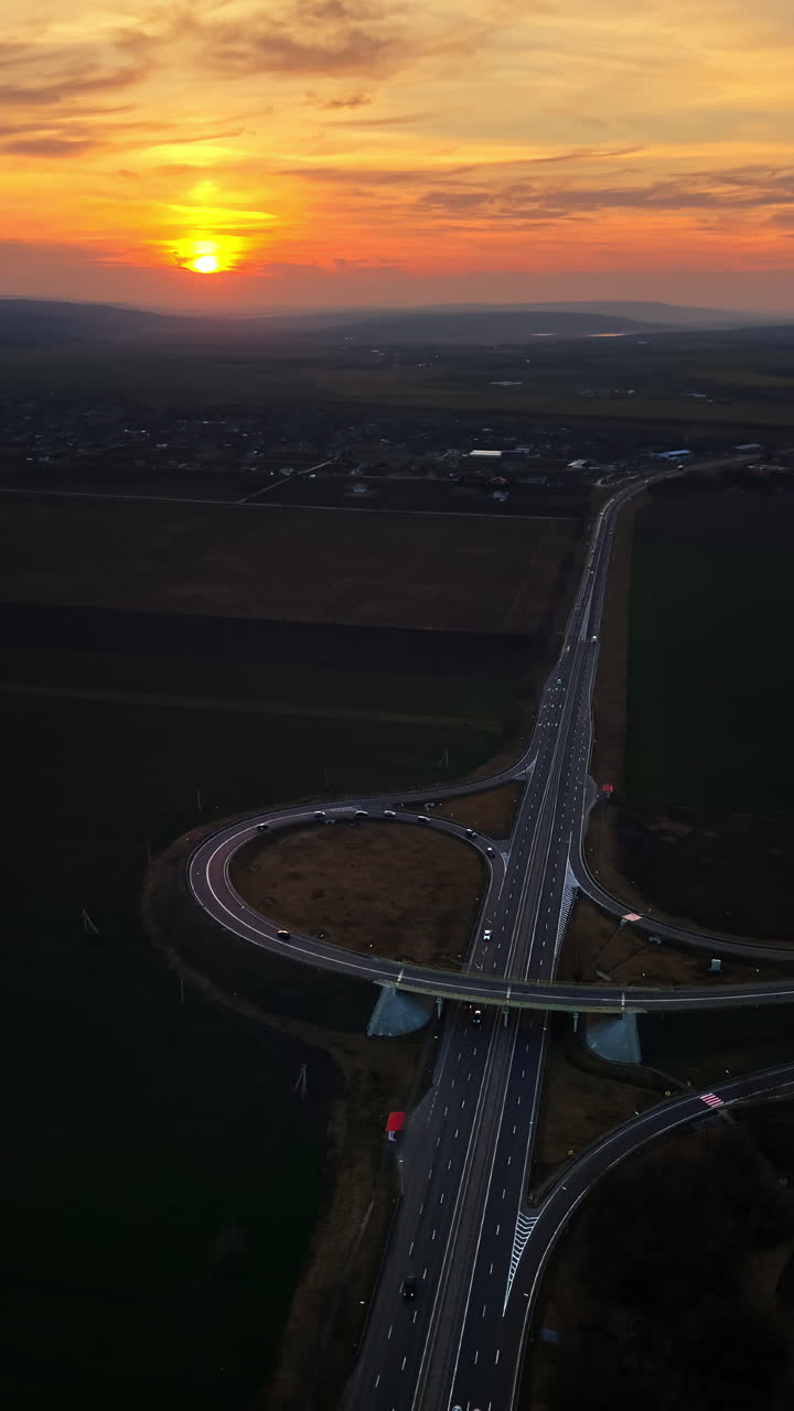 Aerial drone view of cars driving on the highway in Moldova at sunset. Vertical