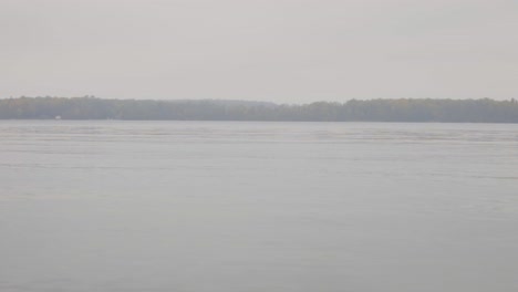 Overcast-Sky-Over-Peaceful-Lake-With-Autumnal-Forest-On-A-Foggy-Day