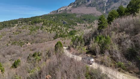 Off-road-car-driving-along-on-dirt-road-on-hillside