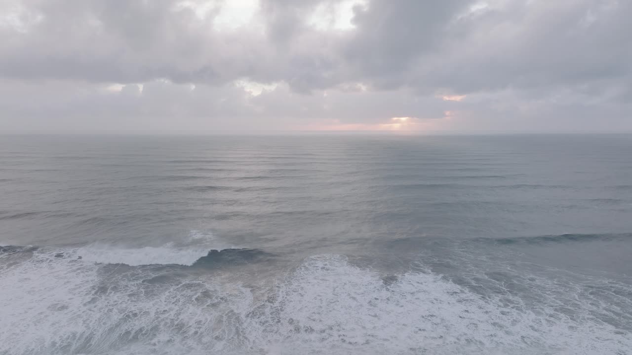 Aerial of ocean waves crashing on Iceland S&oacute;lheimasandur black sand beach, on a cloudy day