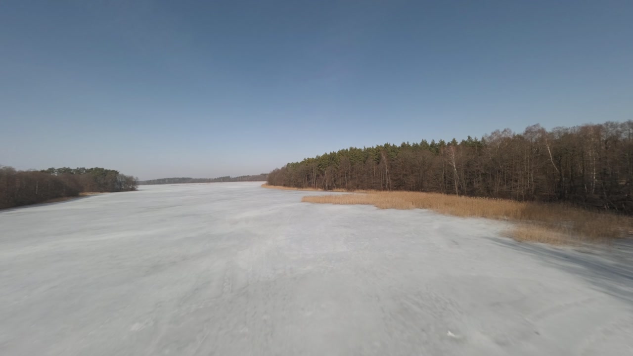Frozen lake landscape filmed with FPV drone in Poland