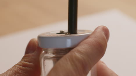 macro shot of using a pencil sharpener with the left hand