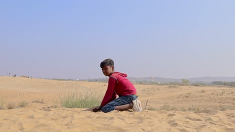 niño jugando con arena amarilla en el desierto durante el día el video fue tomado en rajasthan, india