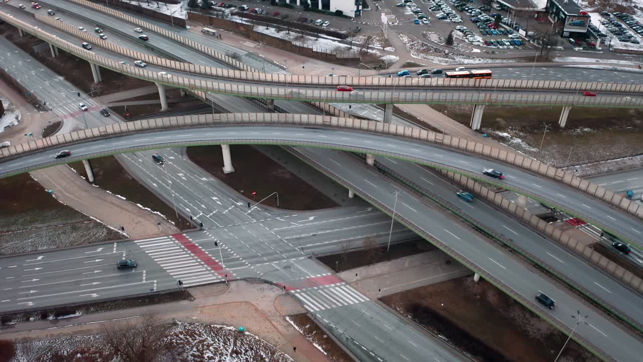 aerial flyover traffic jam interchange road: 겨울 저녁에 도로 교차로, 드론, 현대 도시의 교차로를 위아래로 볼 때, 바쁜 교차로 고속도로를 운전하는 많은 자동차, 고속도로, 서클 로드