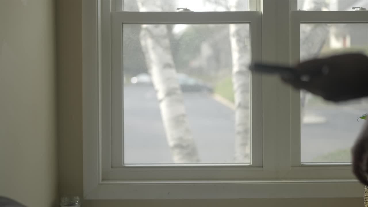 Person calling on the phone next to a window that has just been opened