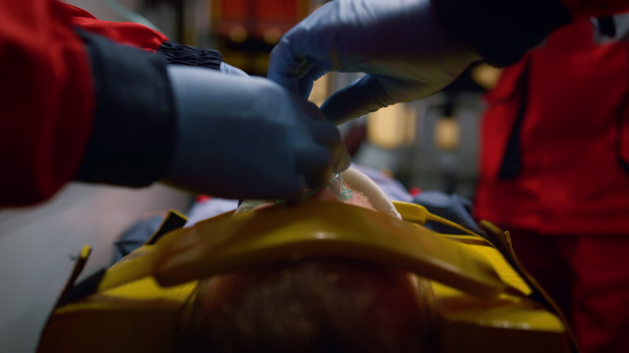 구급차 에 있는 환자 에게 응급 처치 도움 을 주는 장갑 을 입은 구급 요원 들 의 팀
